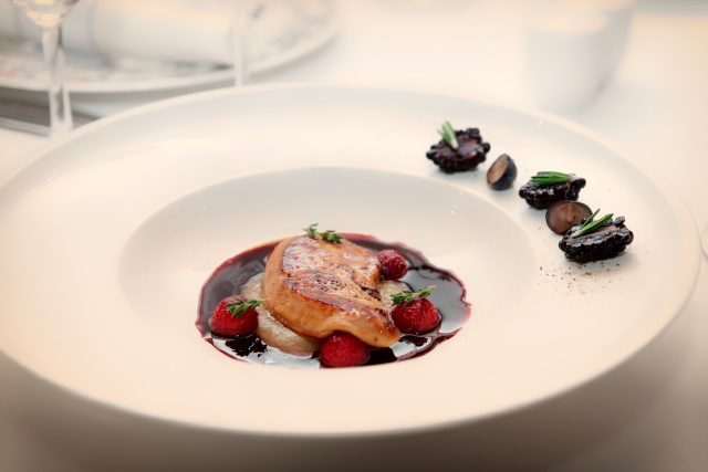 Plate of foie gras in a reduction sauce with berries and truffles